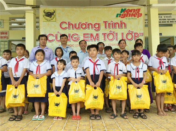 Đại diện lãnh đạo Báo Nông nghiệp, Cty Bình Điền và TT Khuyến nông tỉnh Hậu Giang trao quà cho học sinh.